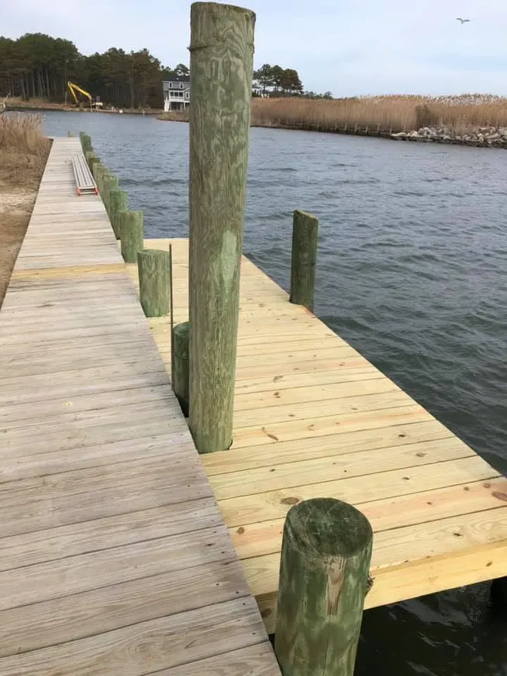 New timber dock on fresh pilings along a marsh creek