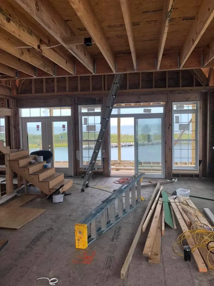 Framed great room with tall windows facing the water