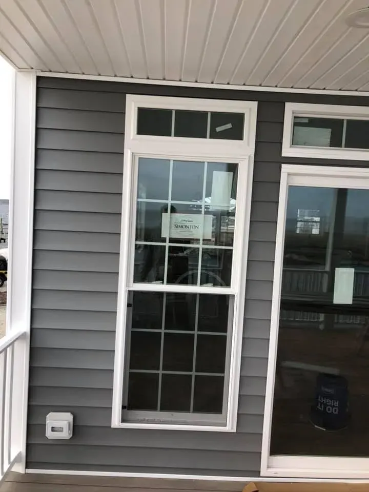 Gray siding with white-trimmed window